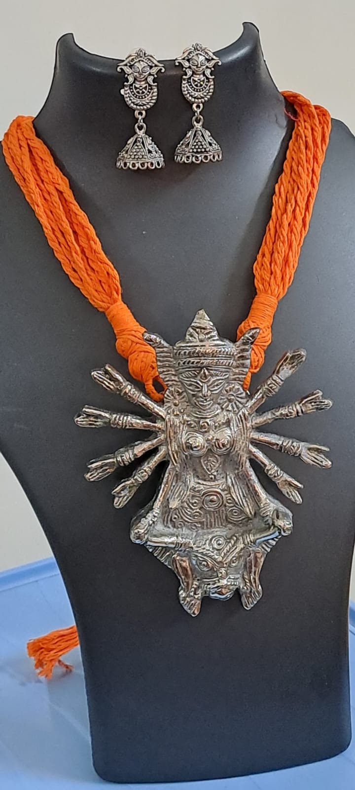 Orange thread necklace with oxidised silver durga pendant