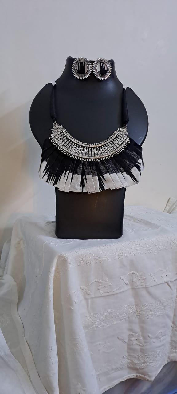 Exclusive necklace with silver oxidised big oval pendant with fabric fringes and matching earrings.