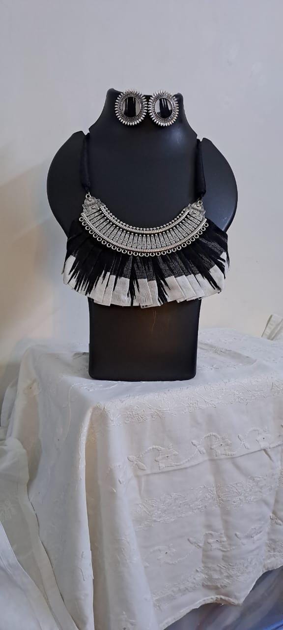 Exclusive necklace with silver oxidised big oval pendant with fabric fringes and matching earrings.