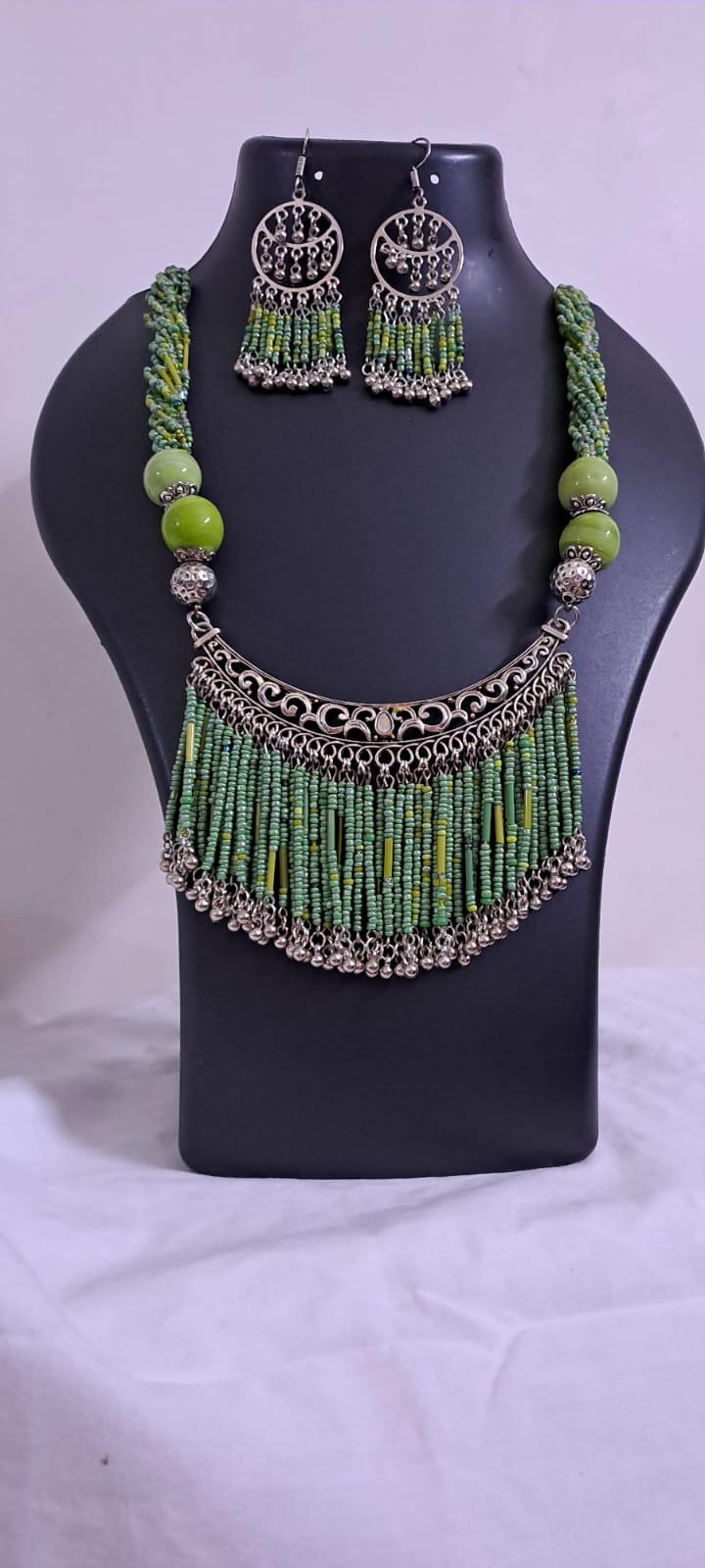 Exclusive necklace with silver oxidised big oval pendant with seed beads fringes and matching earrings.
