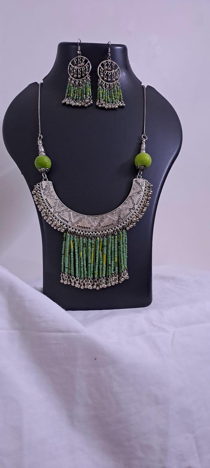 Exclusive necklace with silver oxidised big oval pendant with seed beads fringes and matching earrings.
