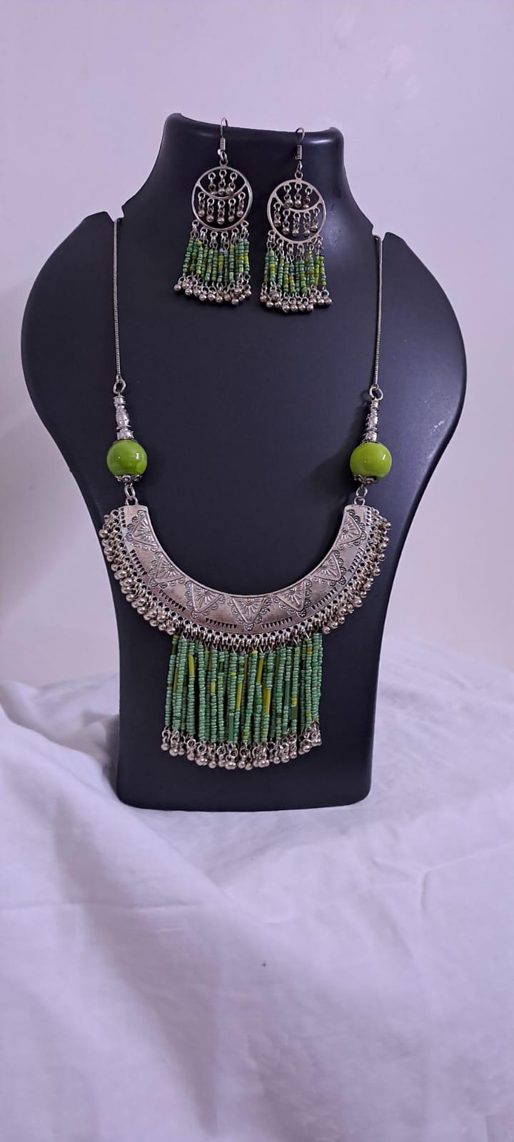 Exclusive necklace with silver oxidised big oval pendant with seed beads fringes and matching earrings.