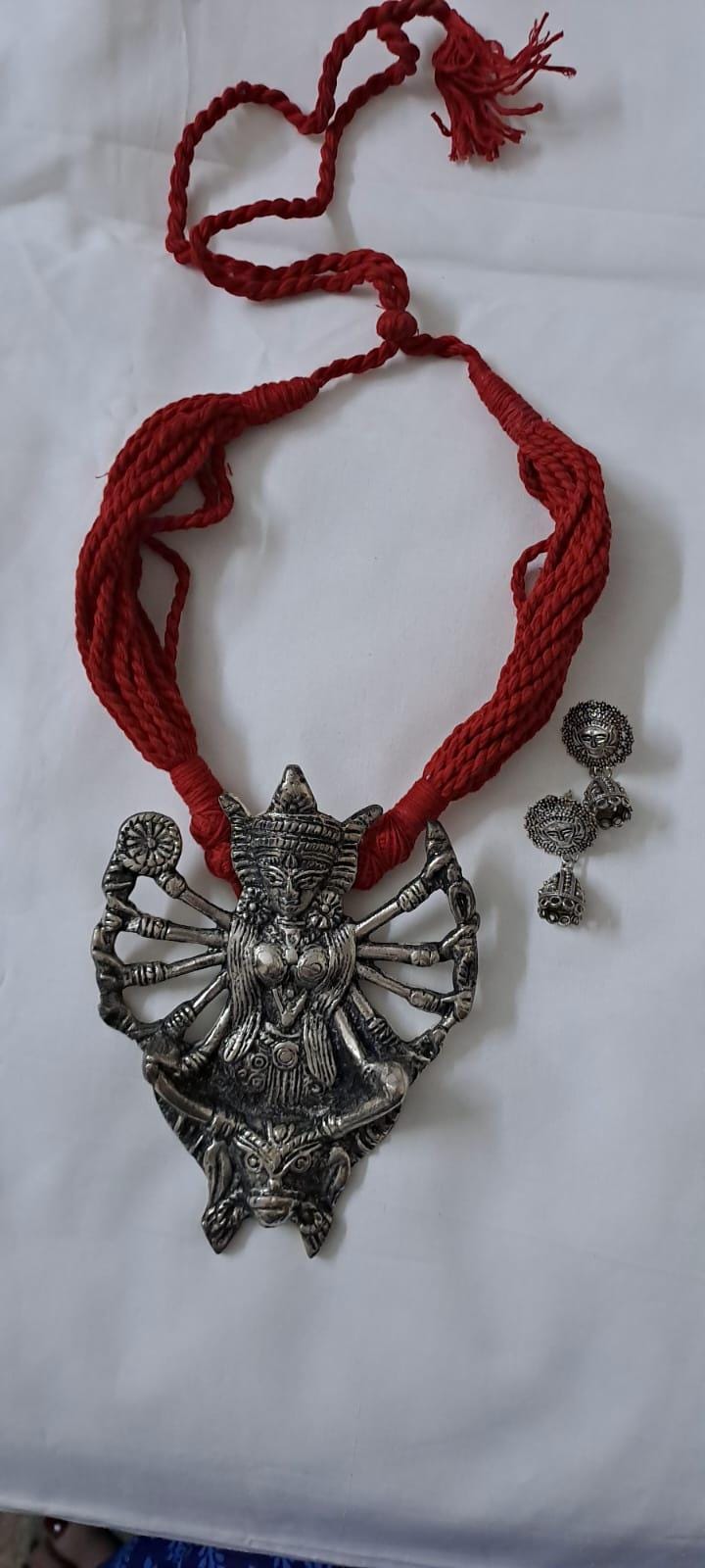Red thread necklace with oxidised silver durga pendant