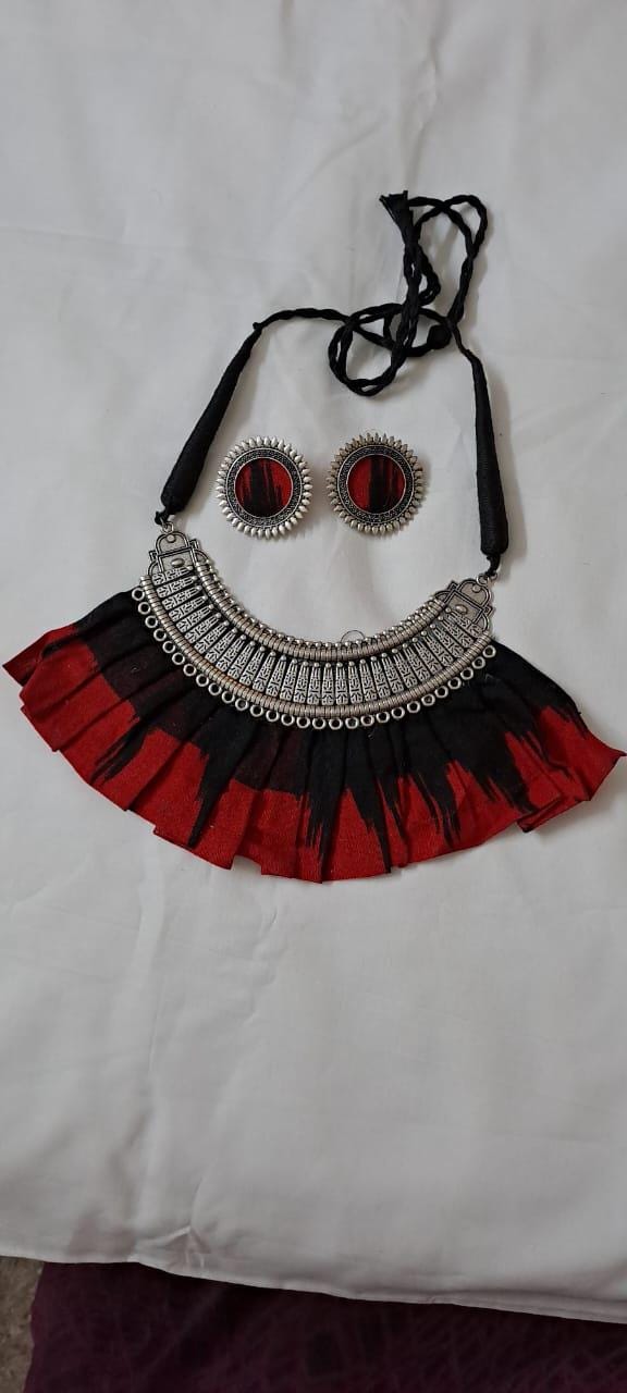 Exclusive necklace with silver oxidised big oval pendant with fabric fringes and matching earrings.