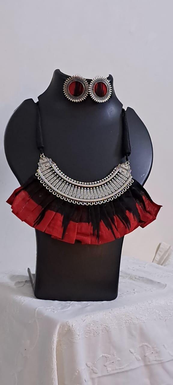 Exclusive necklace with silver oxidised big oval pendant with fabric fringes and matching earrings.