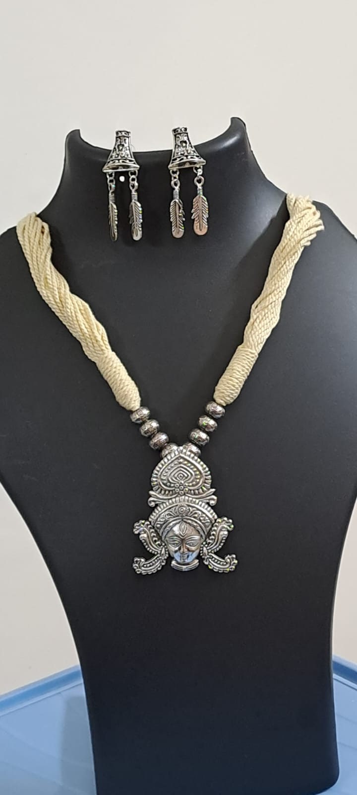 Off white thread necklace with oxidised silver durga pendant