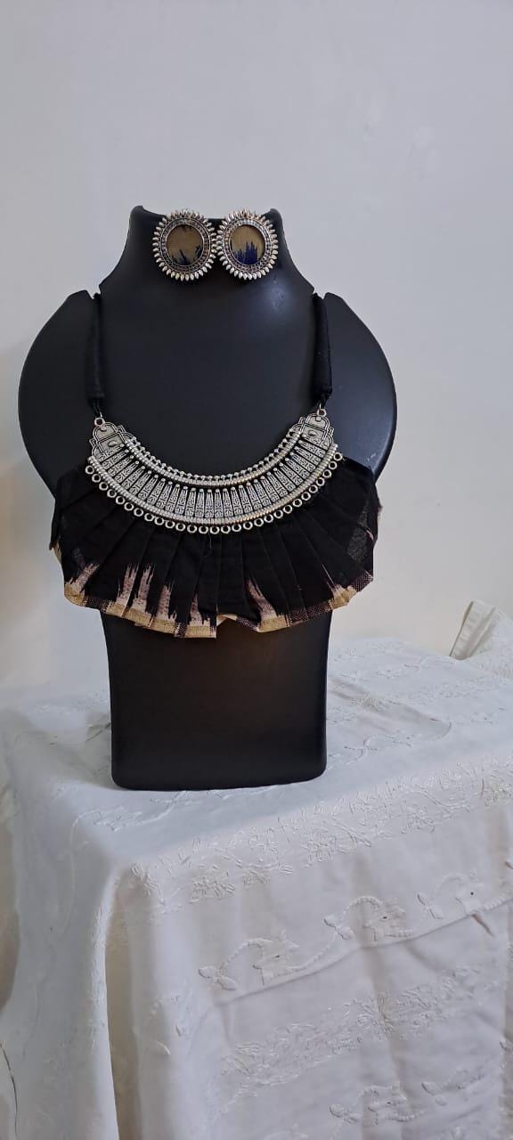 Exclusive necklace with silver oxidised big oval pendant with fabric fringes and matching earrings.