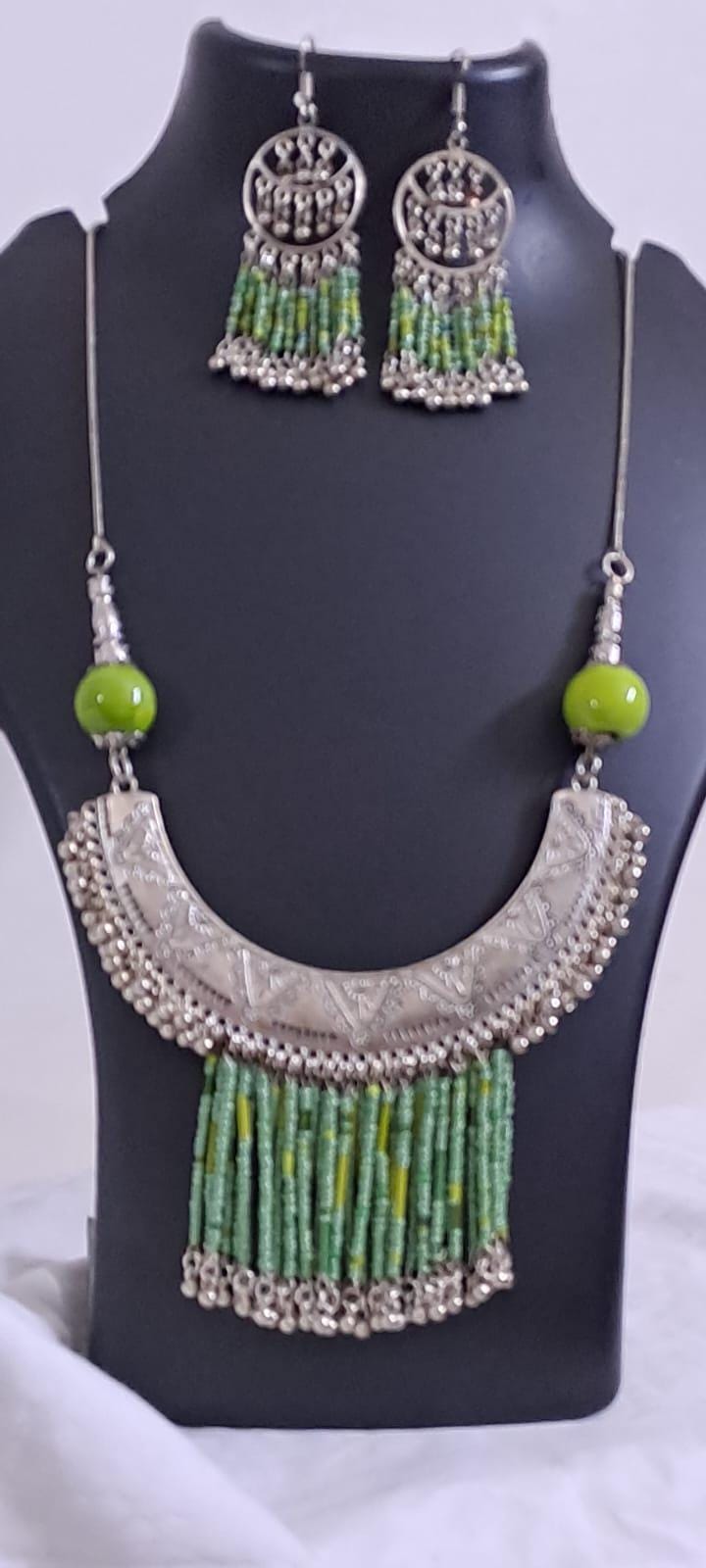 Exclusive necklace with silver oxidised big oval pendant with seed beads fringes and matching earrings.