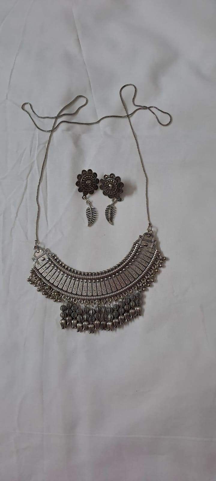 Exclusive necklace with silver oxidised big oval pendant with beads fringes and matching earrings.