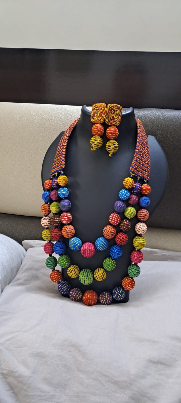 Multi layered and multicoloured necklace with colouful thread ball beads and with matching earrings.