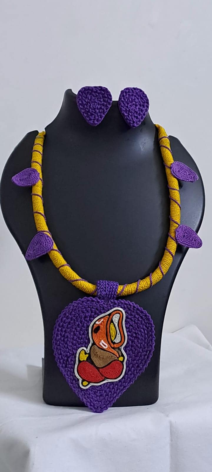 Exclusive yellow and purple thread necklace with leaf shaped  Ganesha thread pendant and matching earrings.