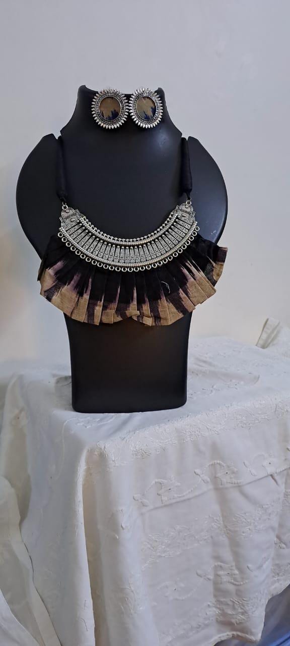 Exclusive necklace with silver oxidised big oval pendant with fabric fringes and matching earrings.