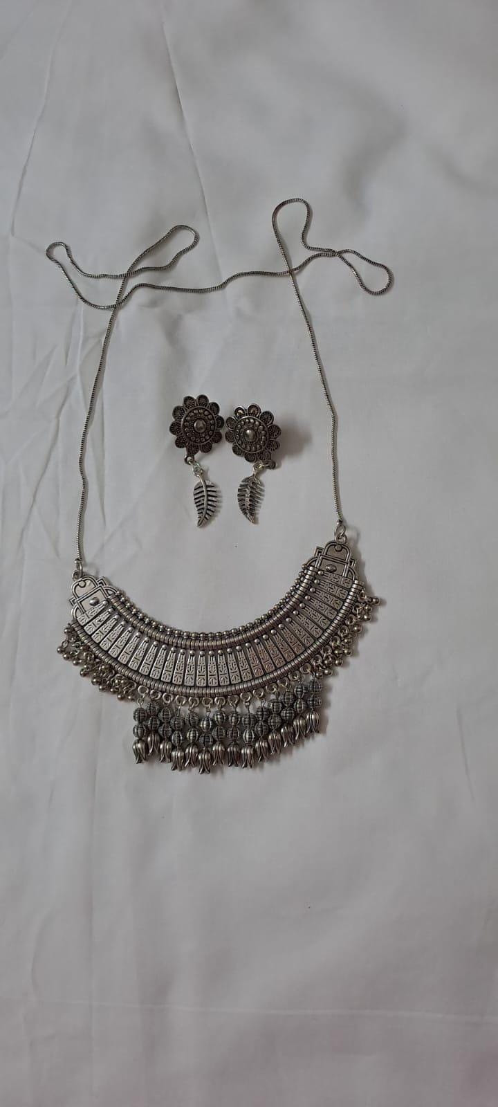 Exclusive necklace with silver oxidised big oval pendant with beads fringes and matching earrings.