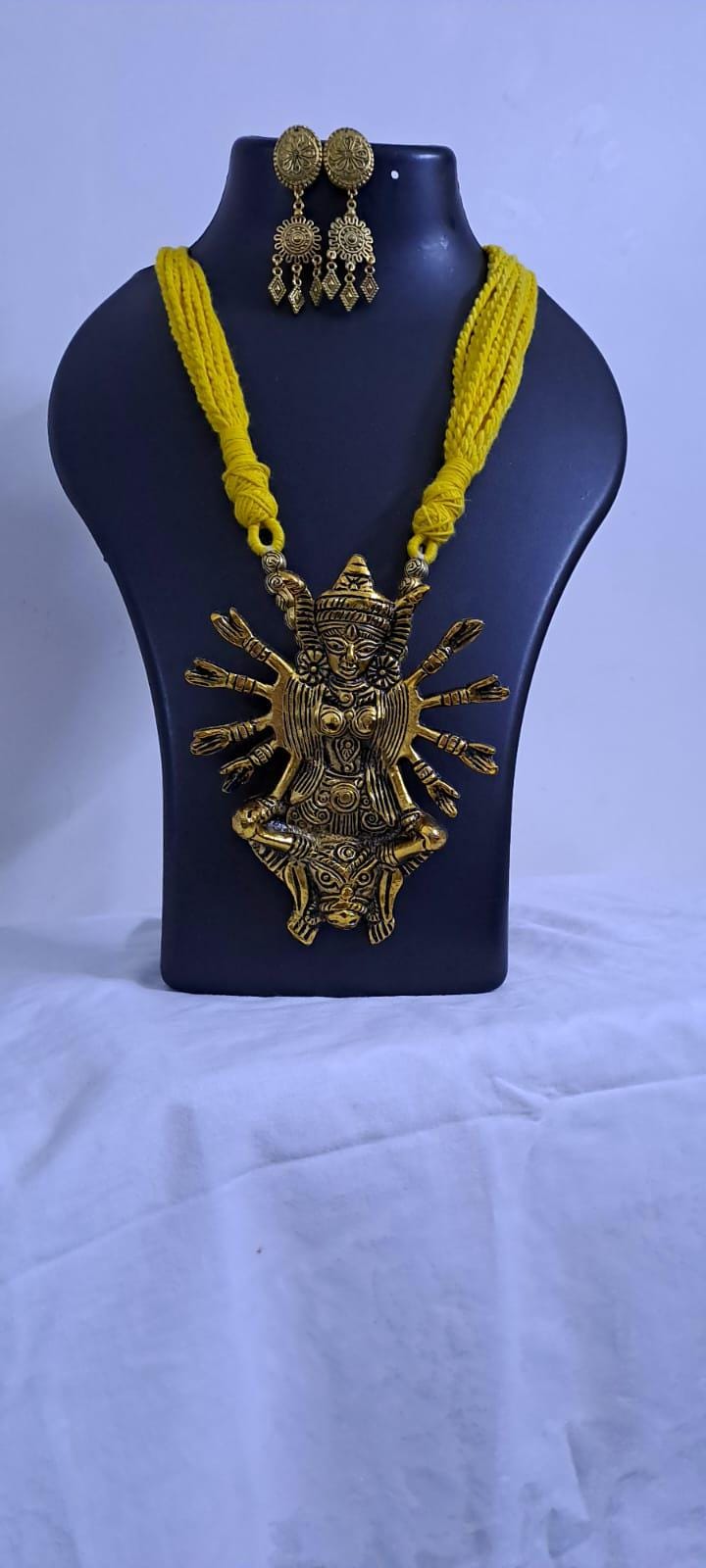 Yellow thread necklace with oxidised golden durga pendant