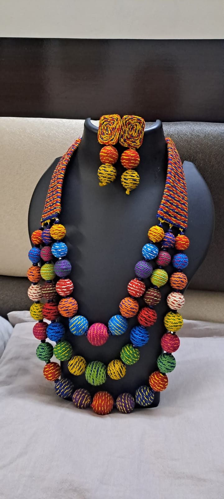 Multi layered and multicoloured necklace with colouful thread ball beads and with matching earrings.
