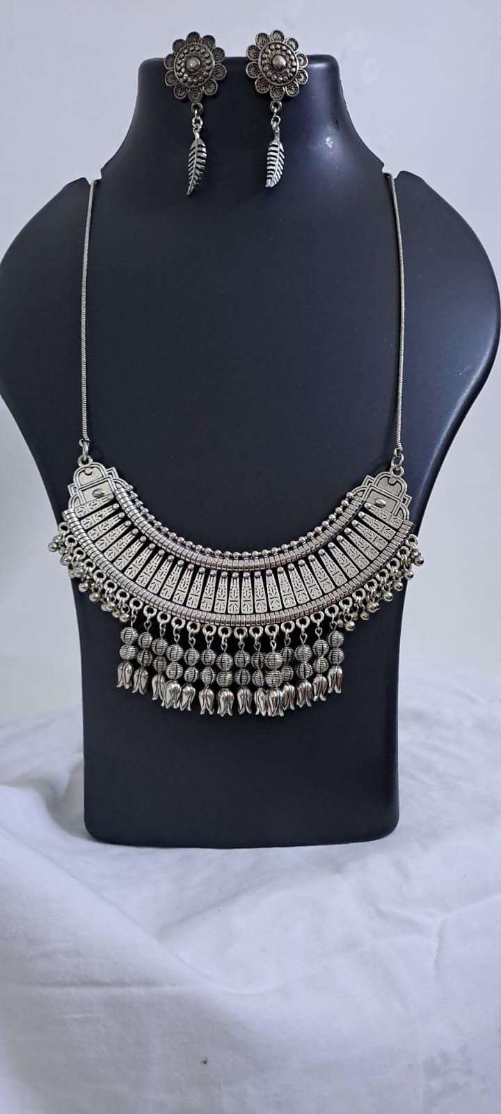 Exclusive necklace with silver oxidised big oval pendant with beads fringes and matching earrings.