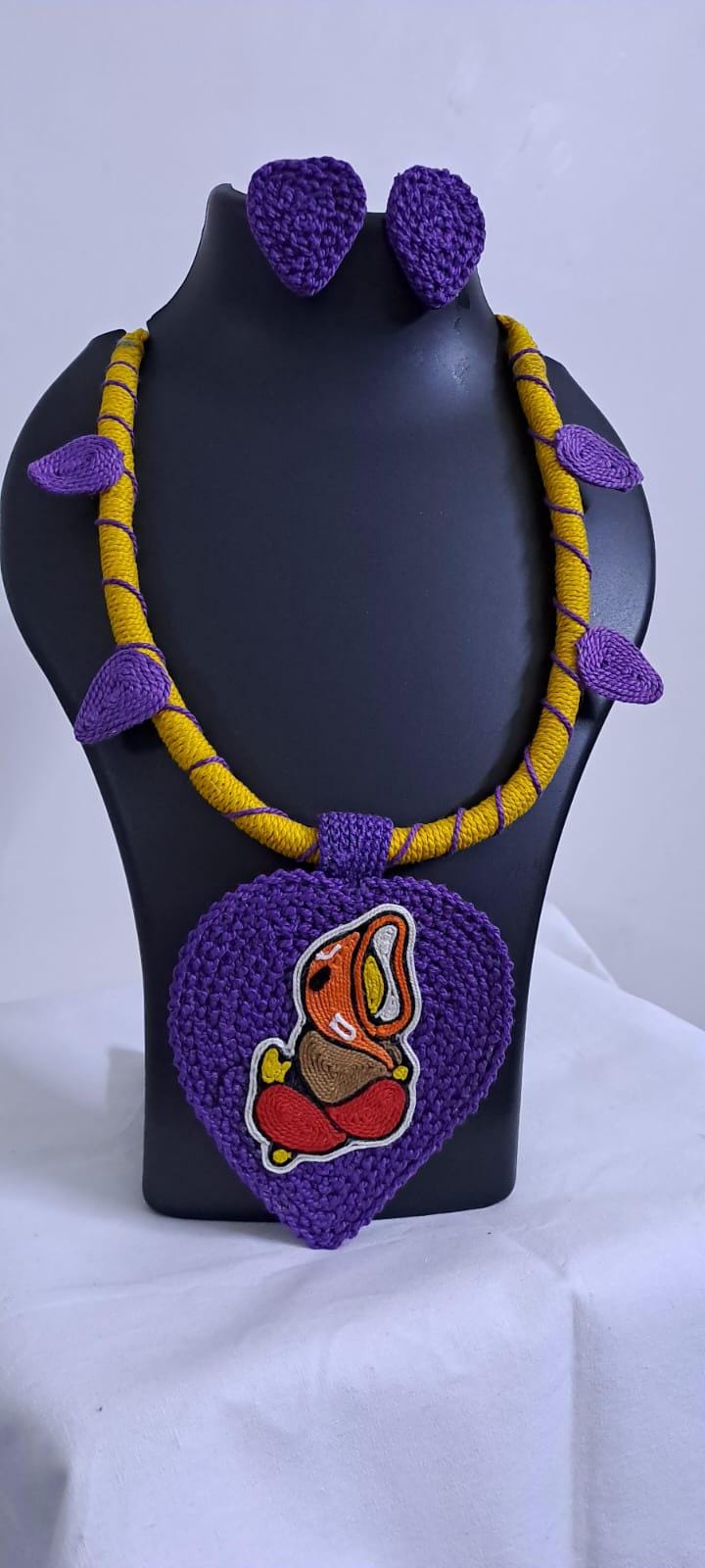 Exclusive yellow and purple thread necklace with leaf shaped  Ganesha thread pendant and matching earrings.
