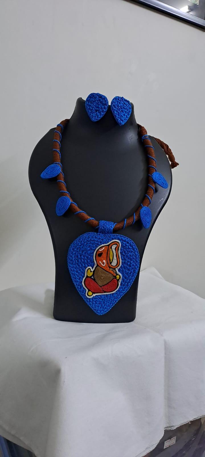 Exclusive brown and blue thread necklace with leaf shaped  Ganesha thread pendant and matching earrings.