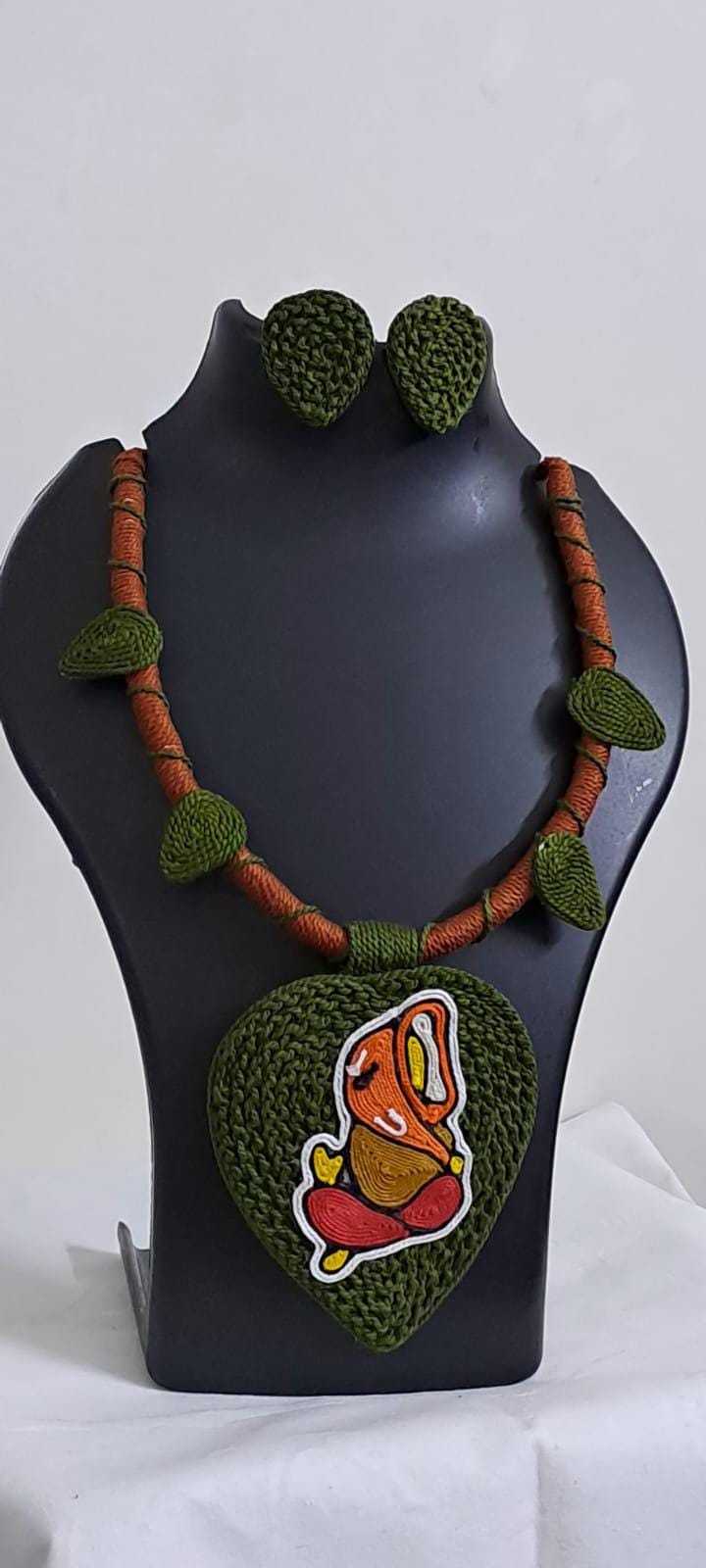 Exclusive forest green and brown thread necklace with leaf shaped  Ganesha thread pendant and matching earrings.