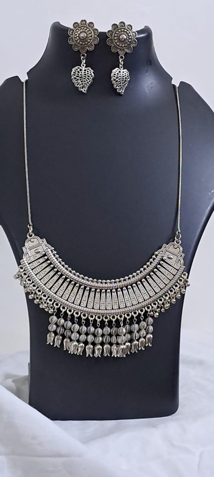 Exclusive necklace with silver oxidised big oval pendant with beads fringes and matching earrings.