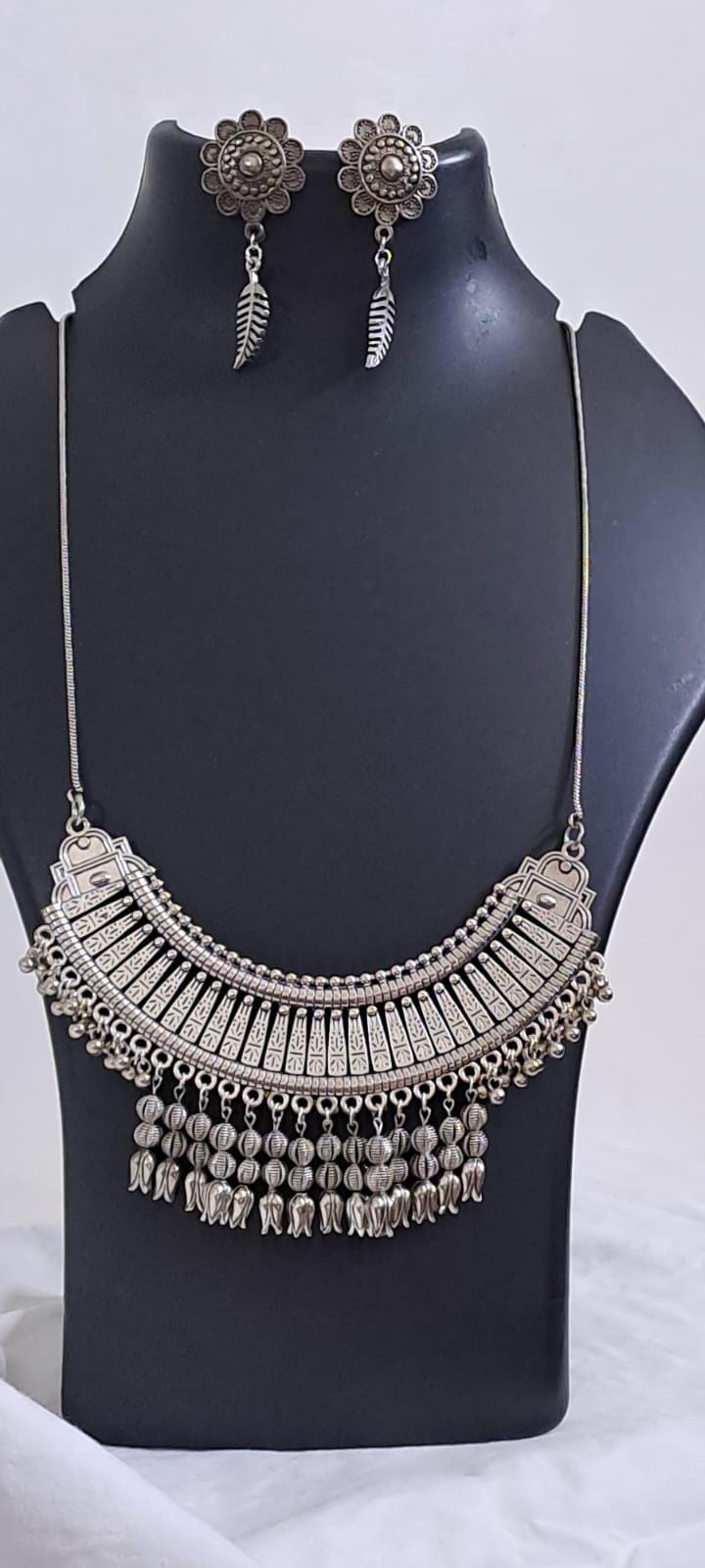 Exclusive necklace with silver oxidised big oval pendant with beads fringes and matching earrings.