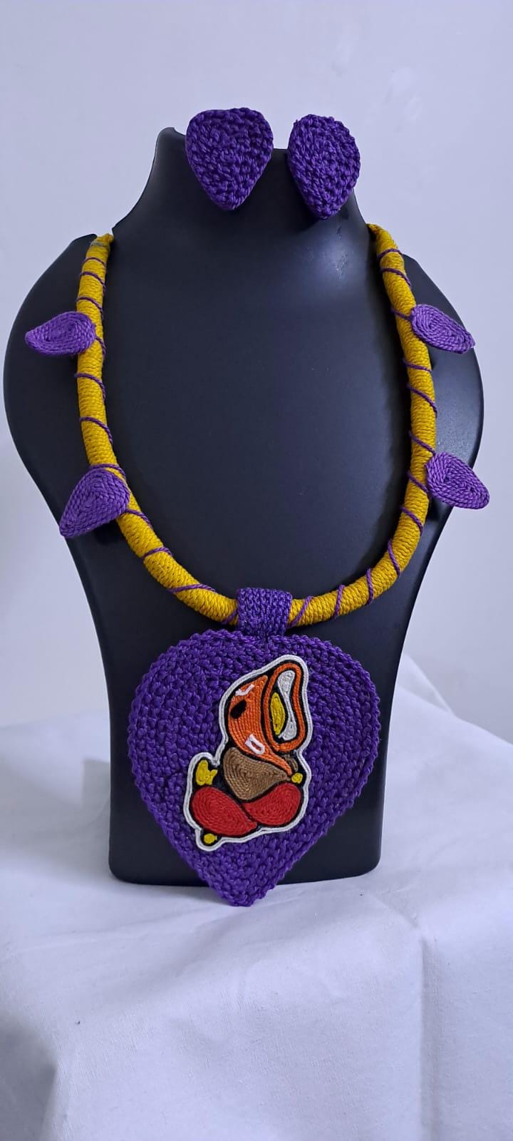 Exclusive yellow and purple thread necklace with leaf shaped  Ganesha thread pendant and matching earrings.