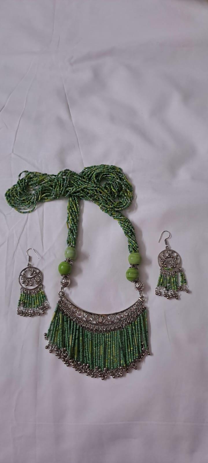 Exclusive necklace with silver oxidised big oval pendant with seed beads fringes and matching earrings.