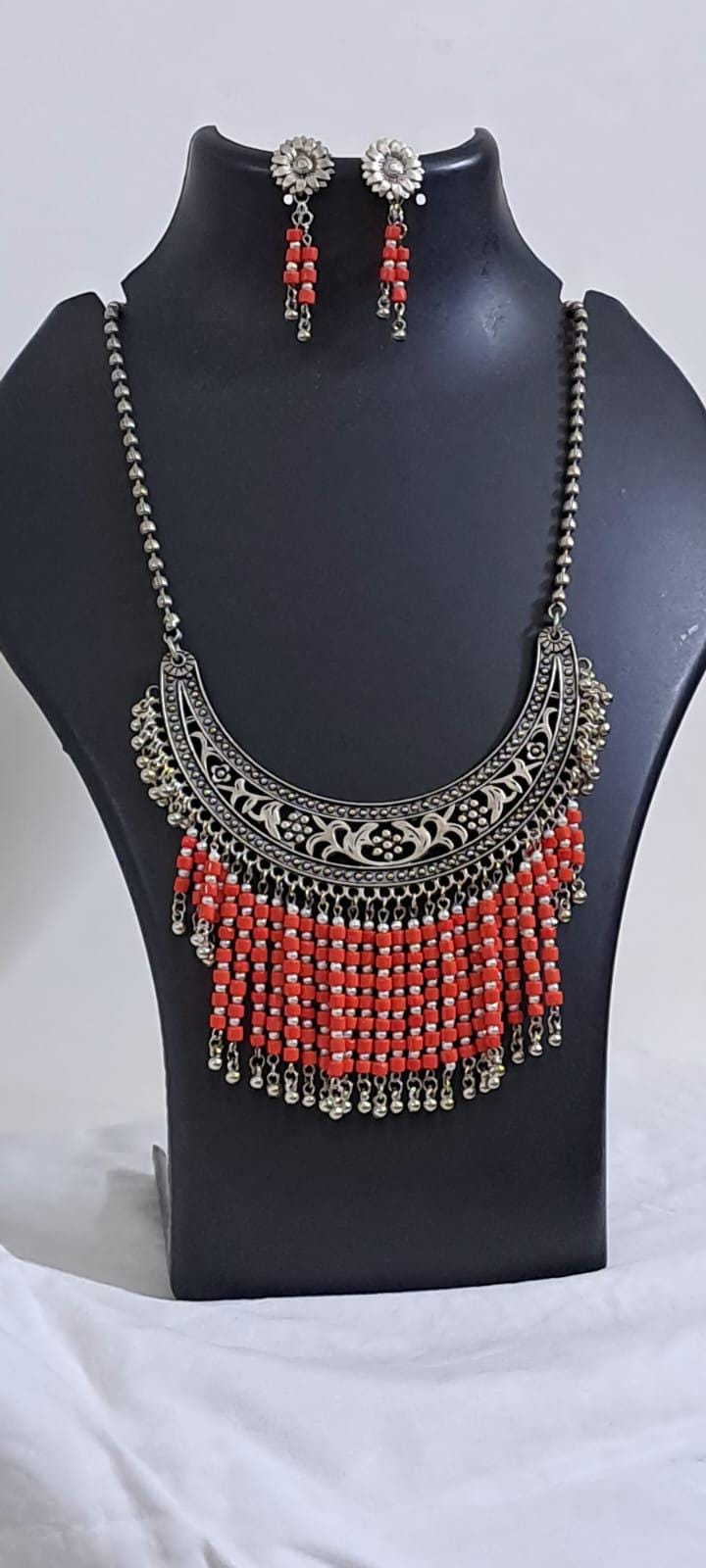 Exclusive necklace with silver oxidised big oval pendant with glass beads fringes and matching earrings.