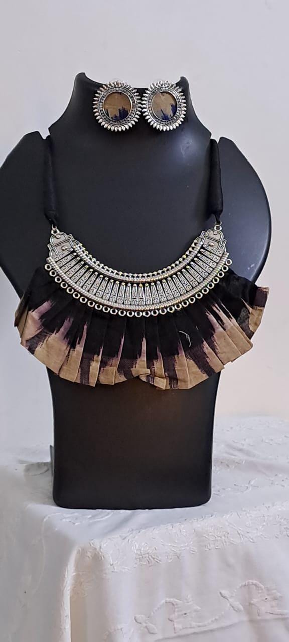 Exclusive necklace with silver oxidised big oval pendant with fabric fringes and matching earrings.