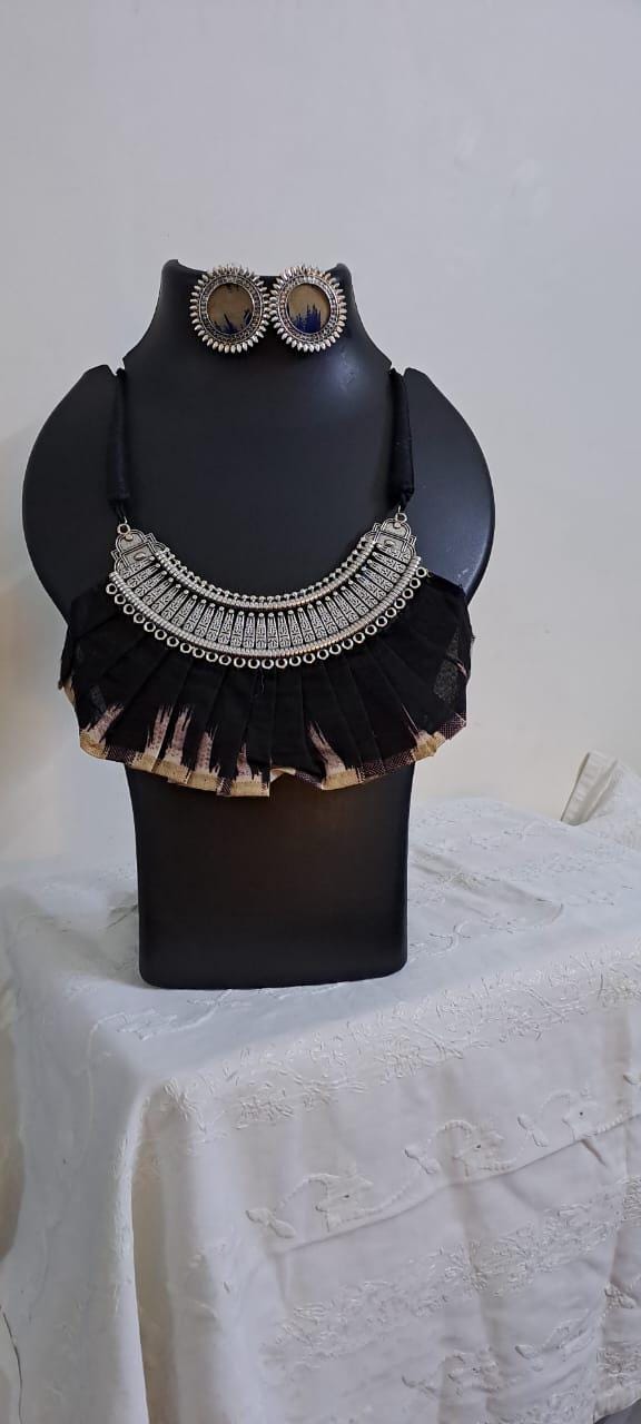 Exclusive necklace with silver oxidised big oval pendant with fabric fringes and matching earrings.