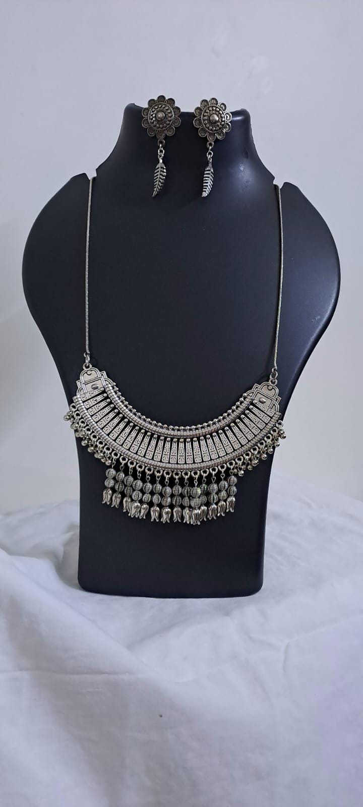 Exclusive necklace with silver oxidised big oval pendant with beads fringes and matching earrings.