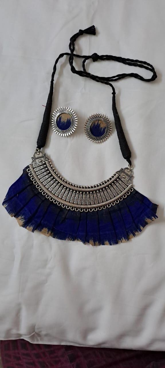 Exclusive necklace with silver oxidised big oval pendant with fabric fringes and matching earrings.