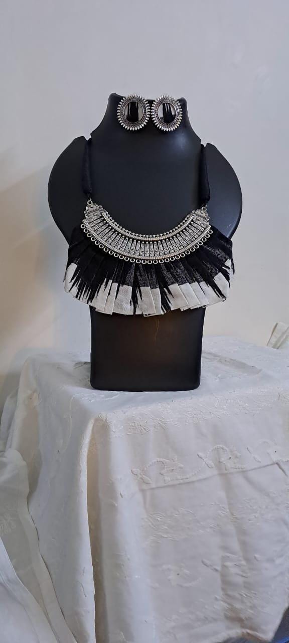 Exclusive necklace with silver oxidised big oval pendant with fabric fringes and matching earrings.