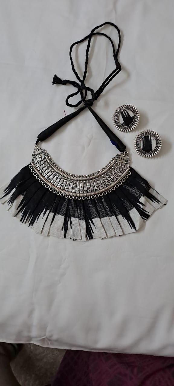 Exclusive necklace with silver oxidised big oval pendant with fabric fringes and matching earrings.