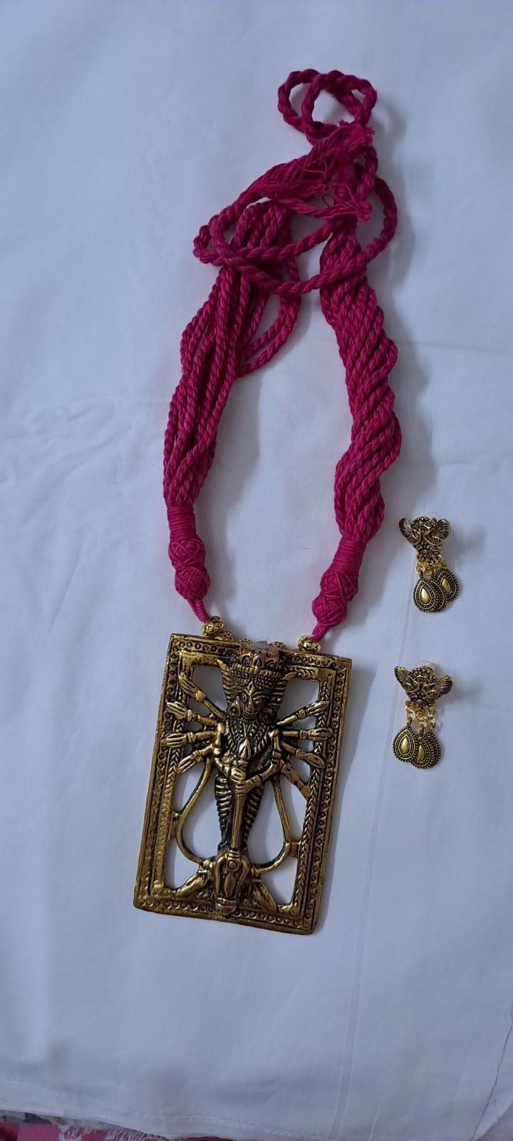Pink thread necklace with oxidised golden durga pendant