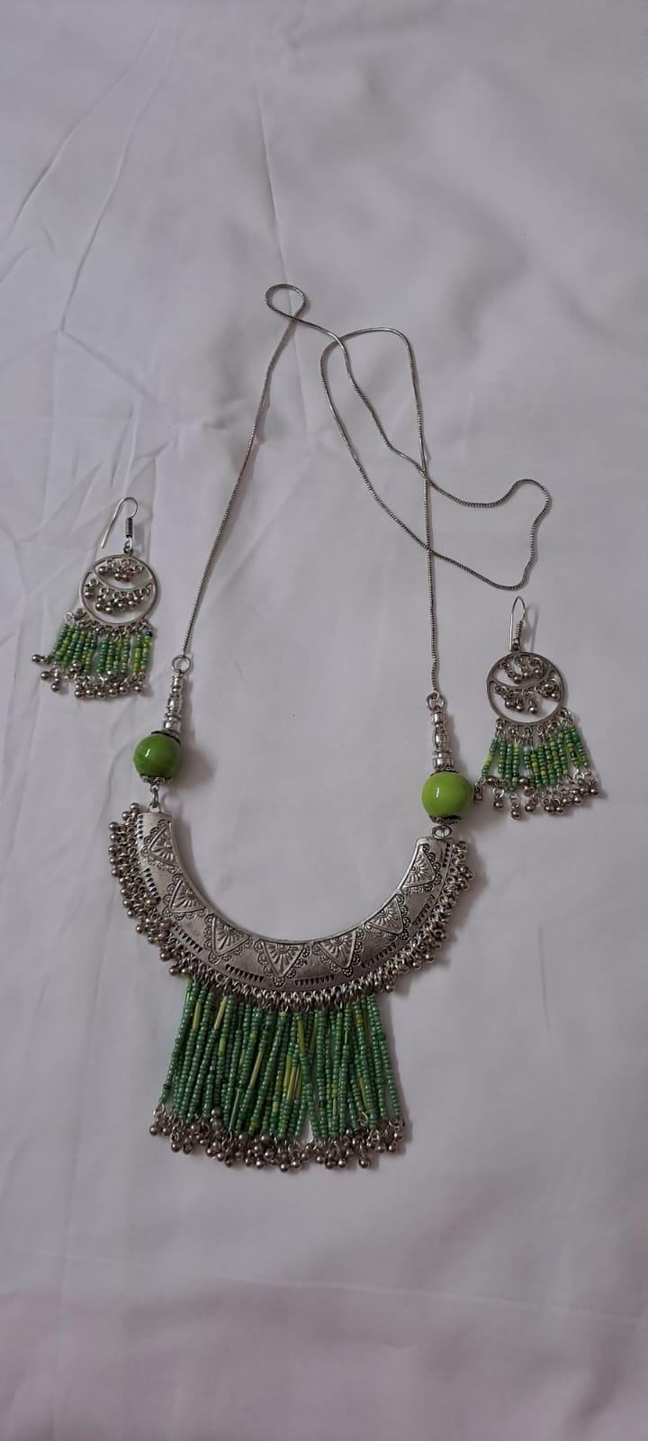 Exclusive necklace with silver oxidised big oval pendant with seed beads fringes and matching earrings.