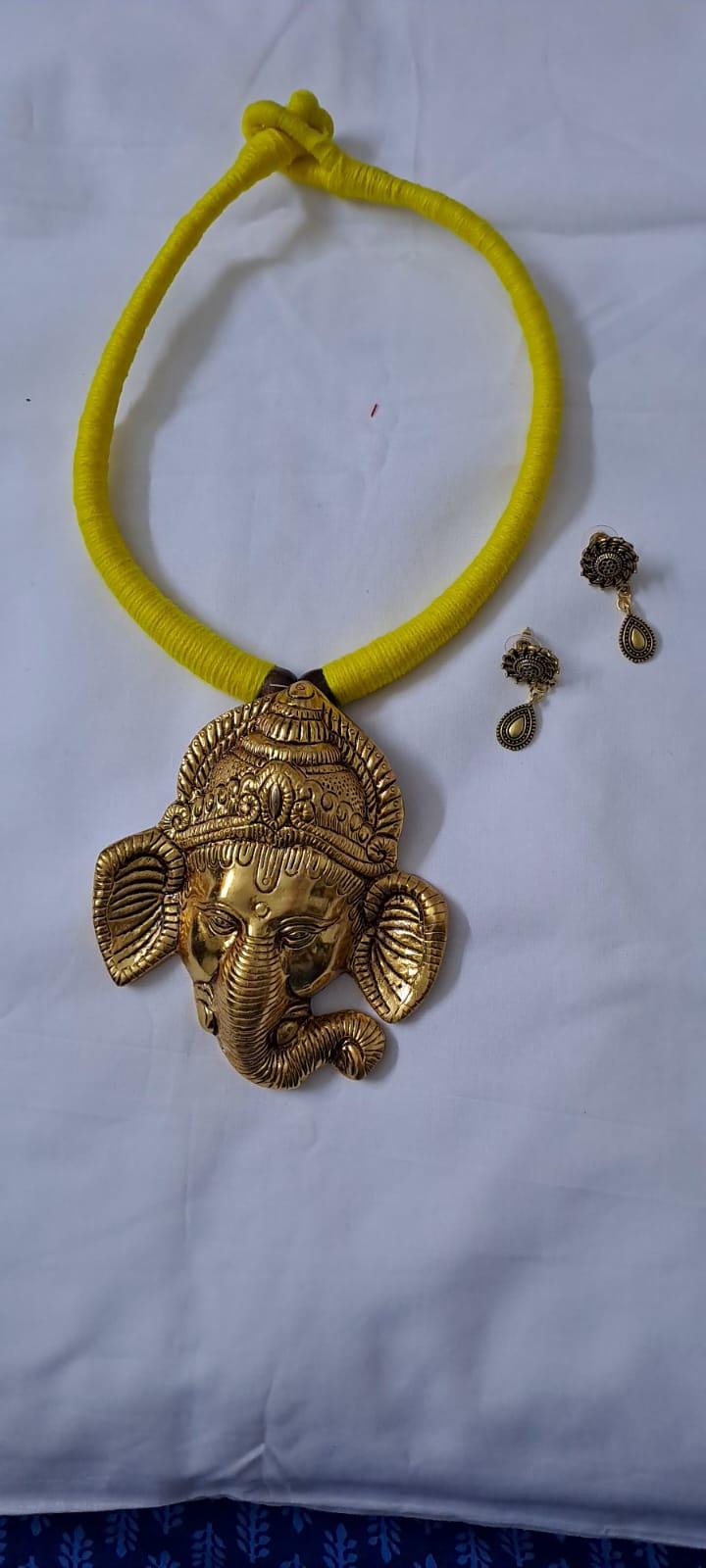 Yellow thread necklace with golden oxidised ganesha pendant