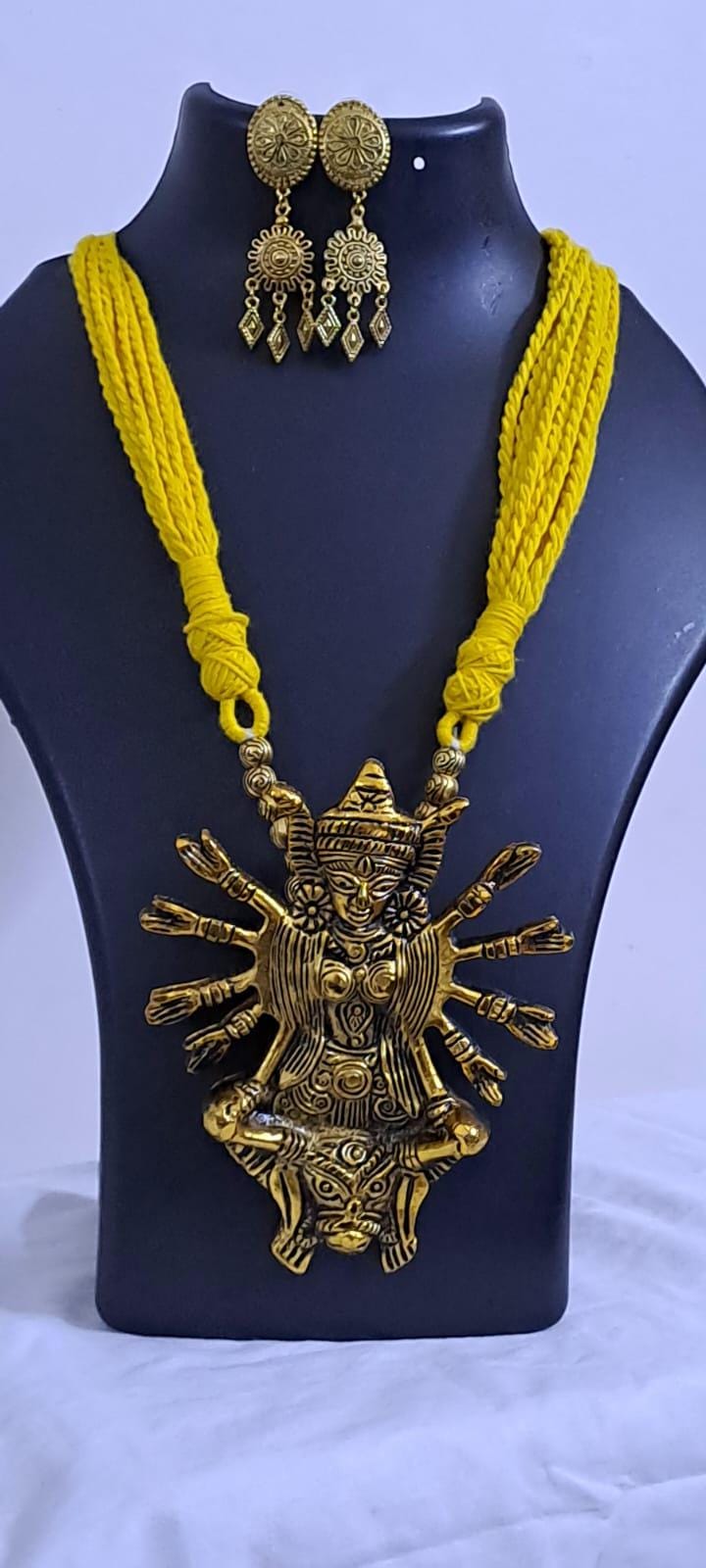 Yellow thread necklace with oxidised golden durga pendant