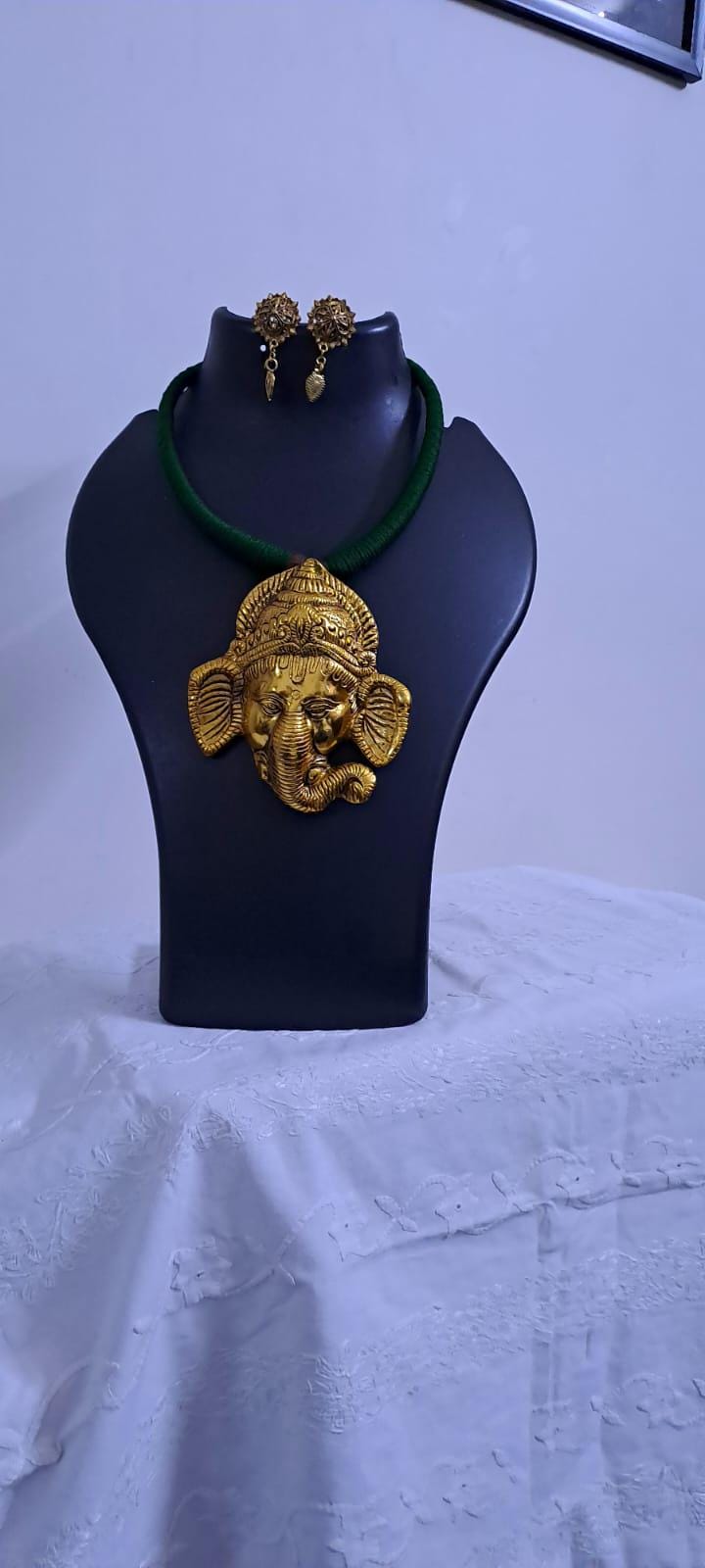 Green thread necklace with golden oxidised ganesha pendant