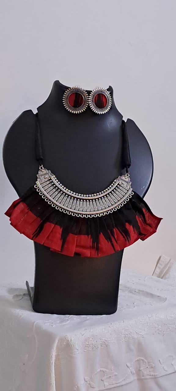 Exclusive necklace with silver oxidised big oval pendant with fabric fringes and matching earrings.