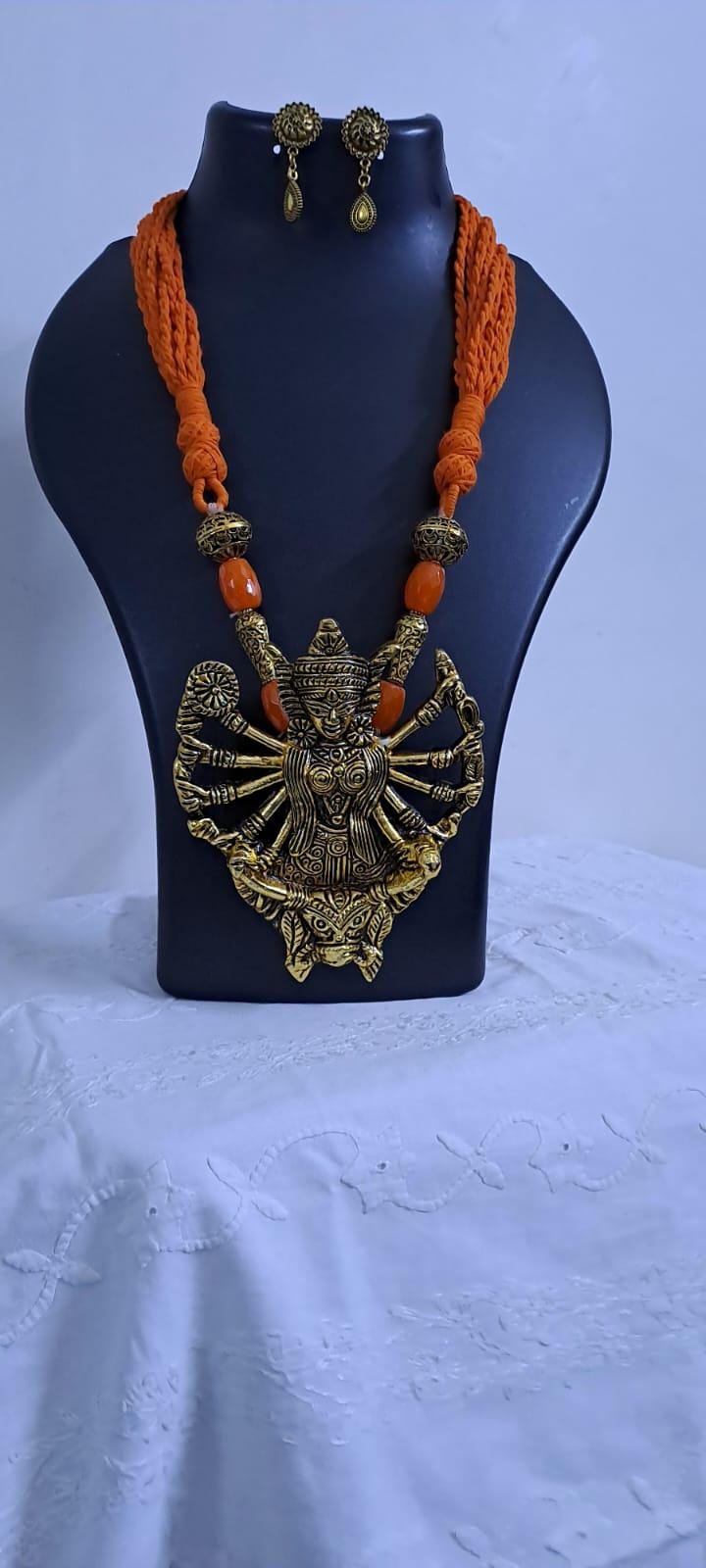 Orange thread necklace with oxidised golden durga pendant