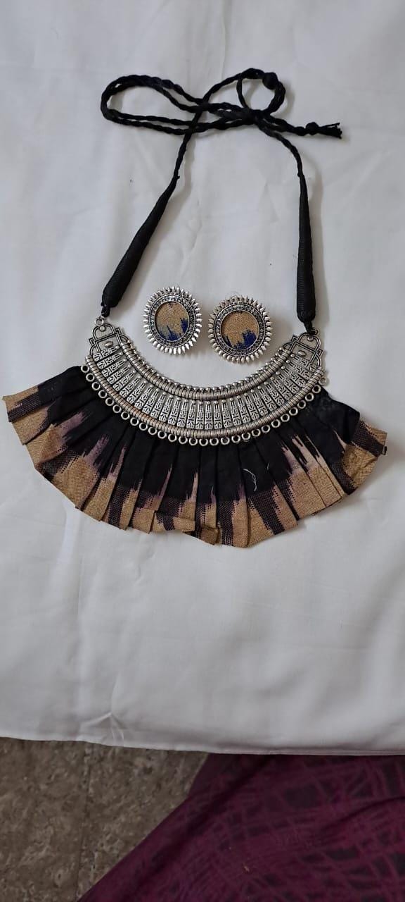 Exclusive necklace with silver oxidised big oval pendant with fabric fringes and matching earrings.