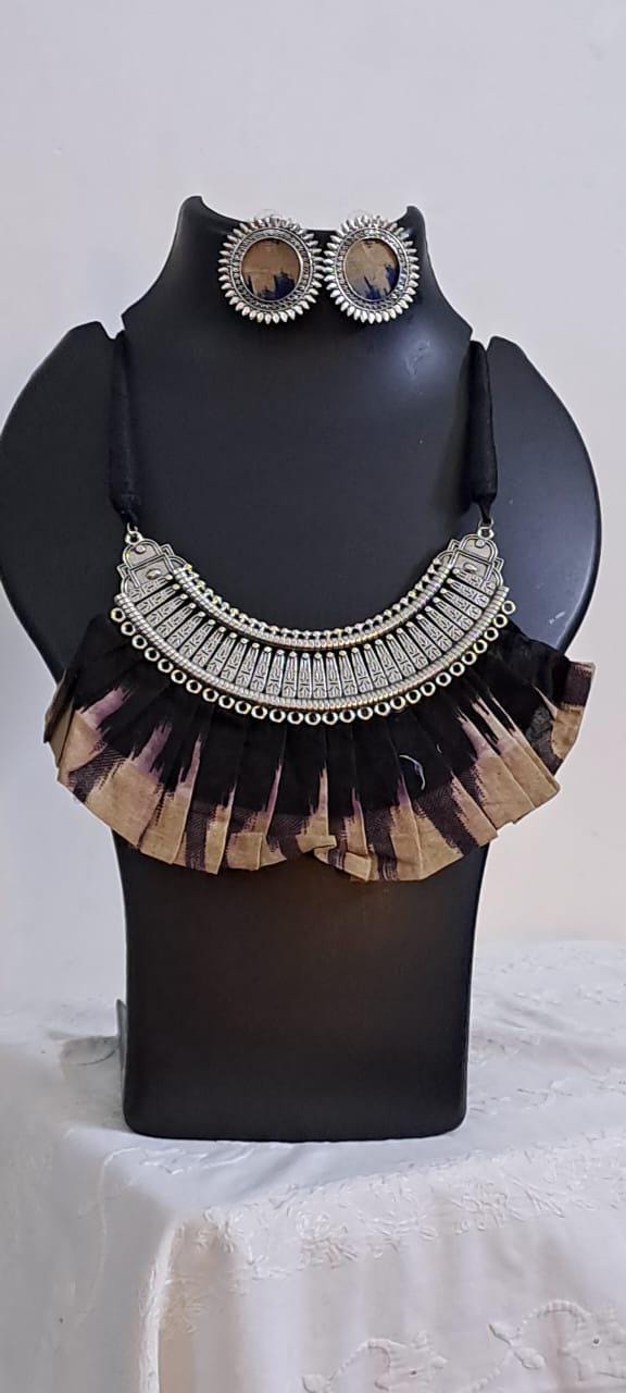 Exclusive necklace with silver oxidised big oval pendant with fabric fringes and matching earrings.