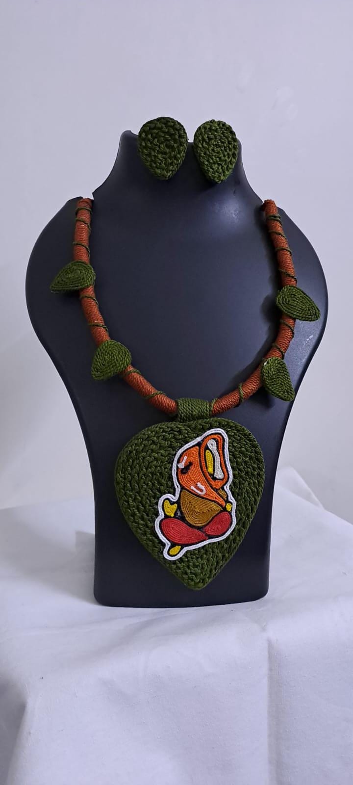 Exclusive forest green and brown thread necklace with leaf shaped  Ganesha thread pendant and matching earrings.