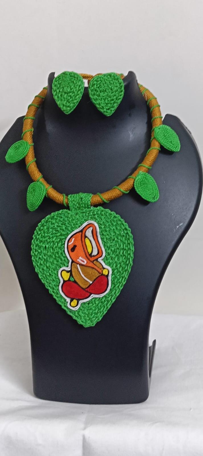 Exclusive light green and brown  thread necklace with leaf shaped  Ganesha pendant  and matching earrings.