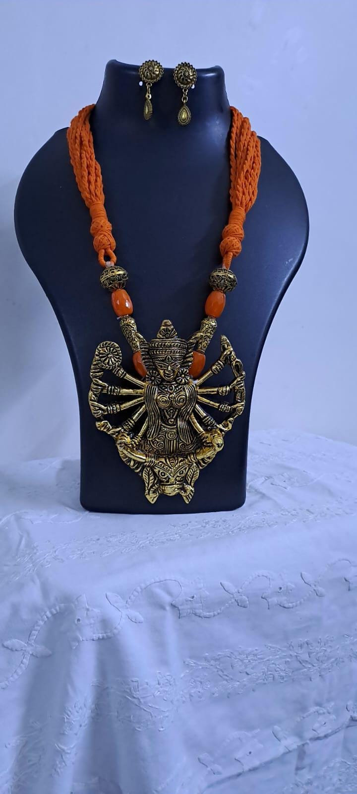 Orange thread necklace with oxidised golden durga pendant