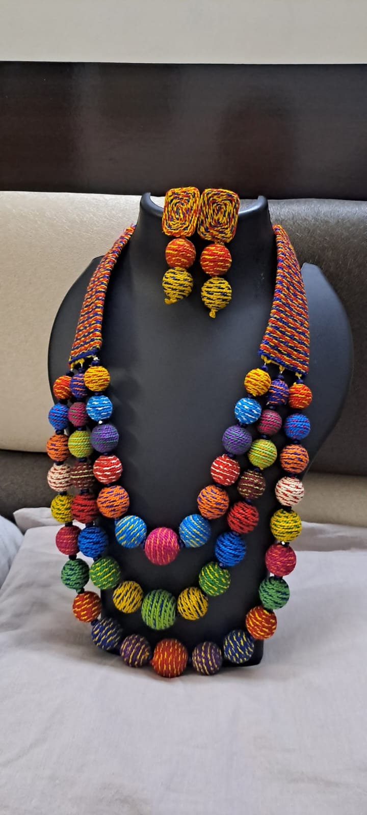 Multi layered and multicoloured necklace with colouful thread ball beads and with matching earrings.