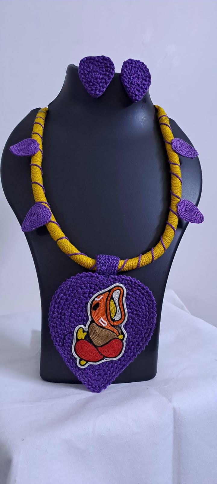 Exclusive yellow and purple thread necklace with leaf shaped  Ganesha thread pendant and matching earrings.