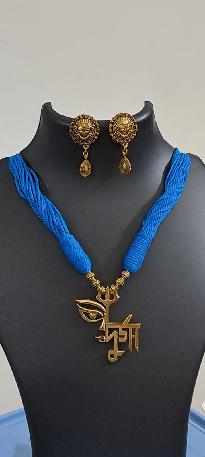 Blue thread necklace with oxidised golden durga pendant