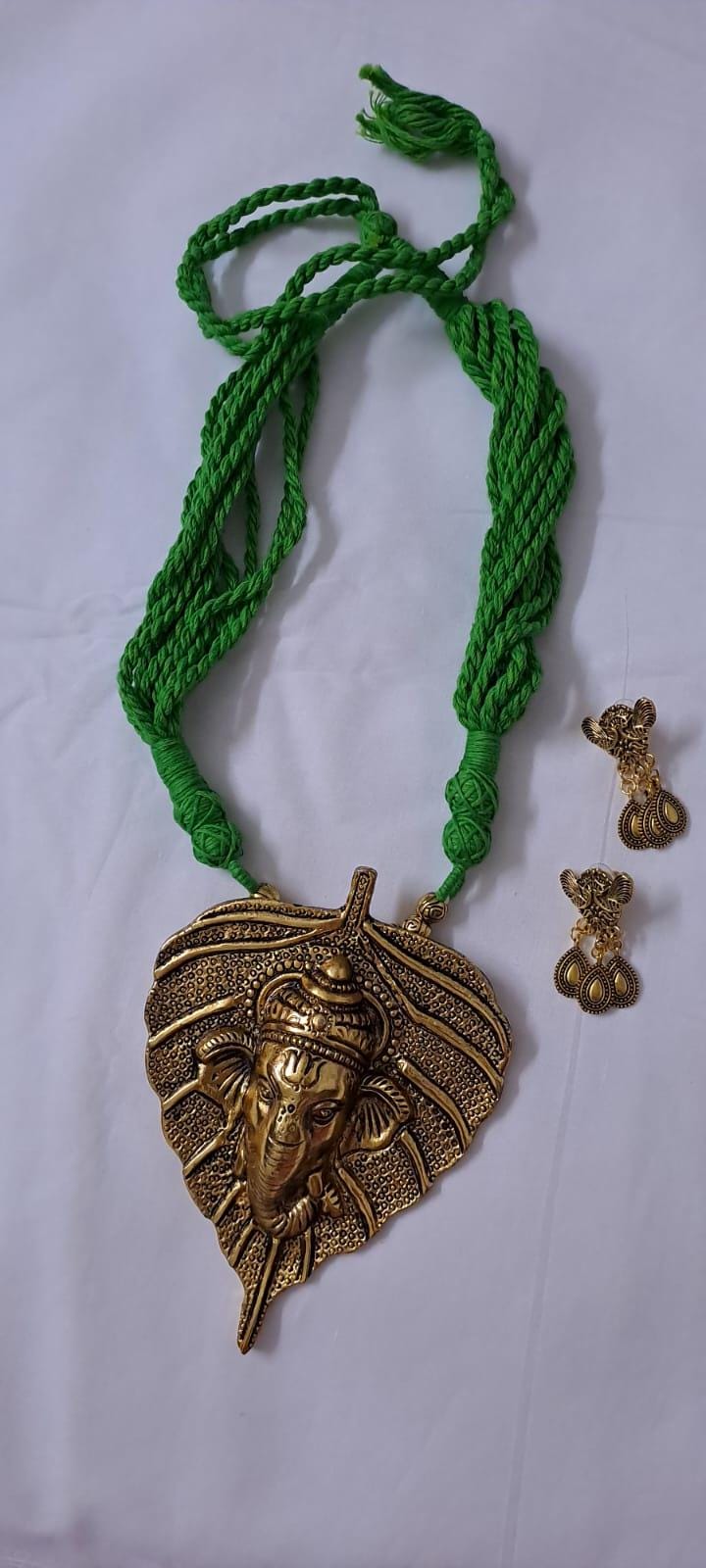 Green thread necklace with golden oxidised ganesha pendant